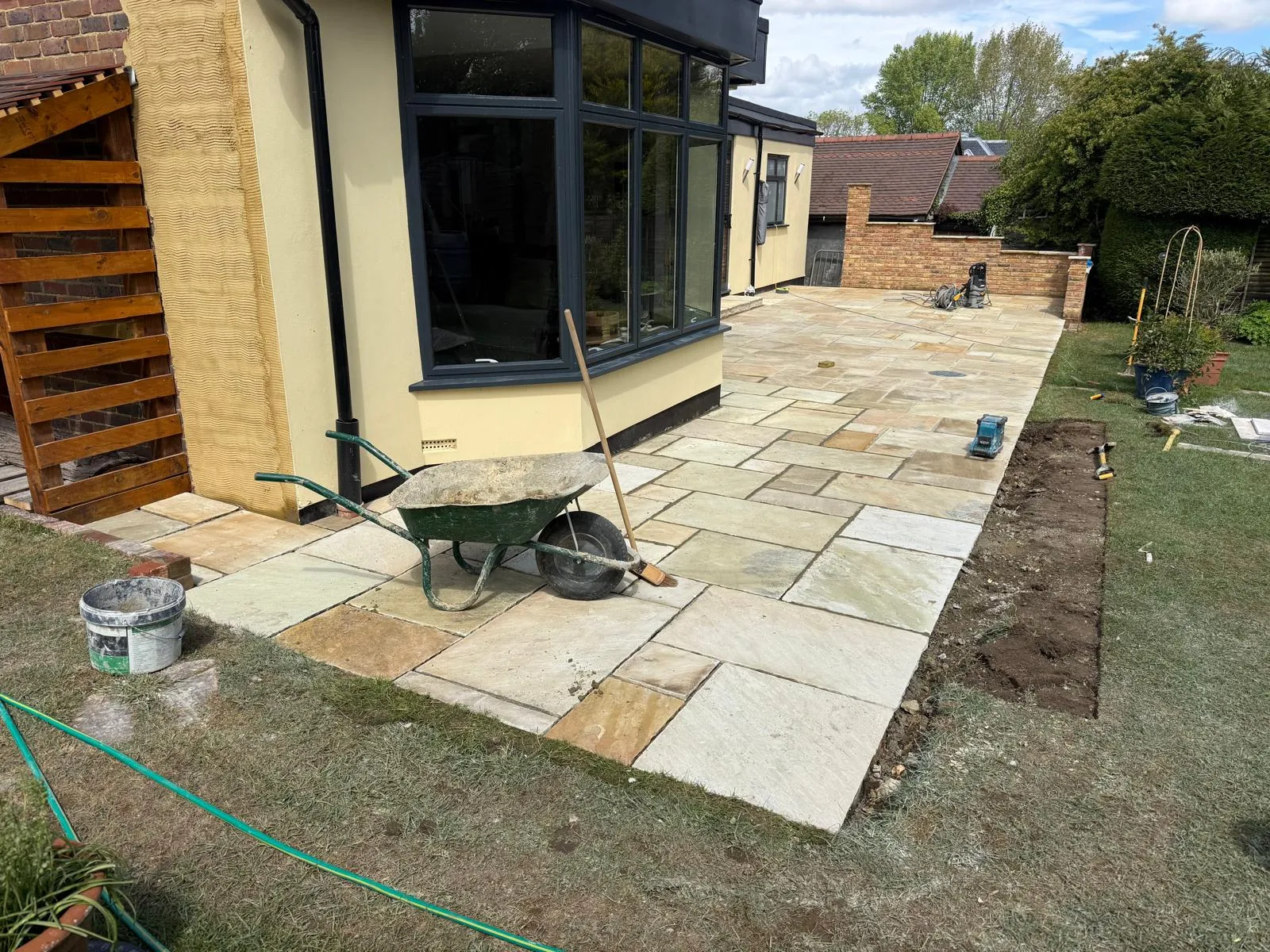 New Indian sandstone paving being laid over a prepared base in Downe Village