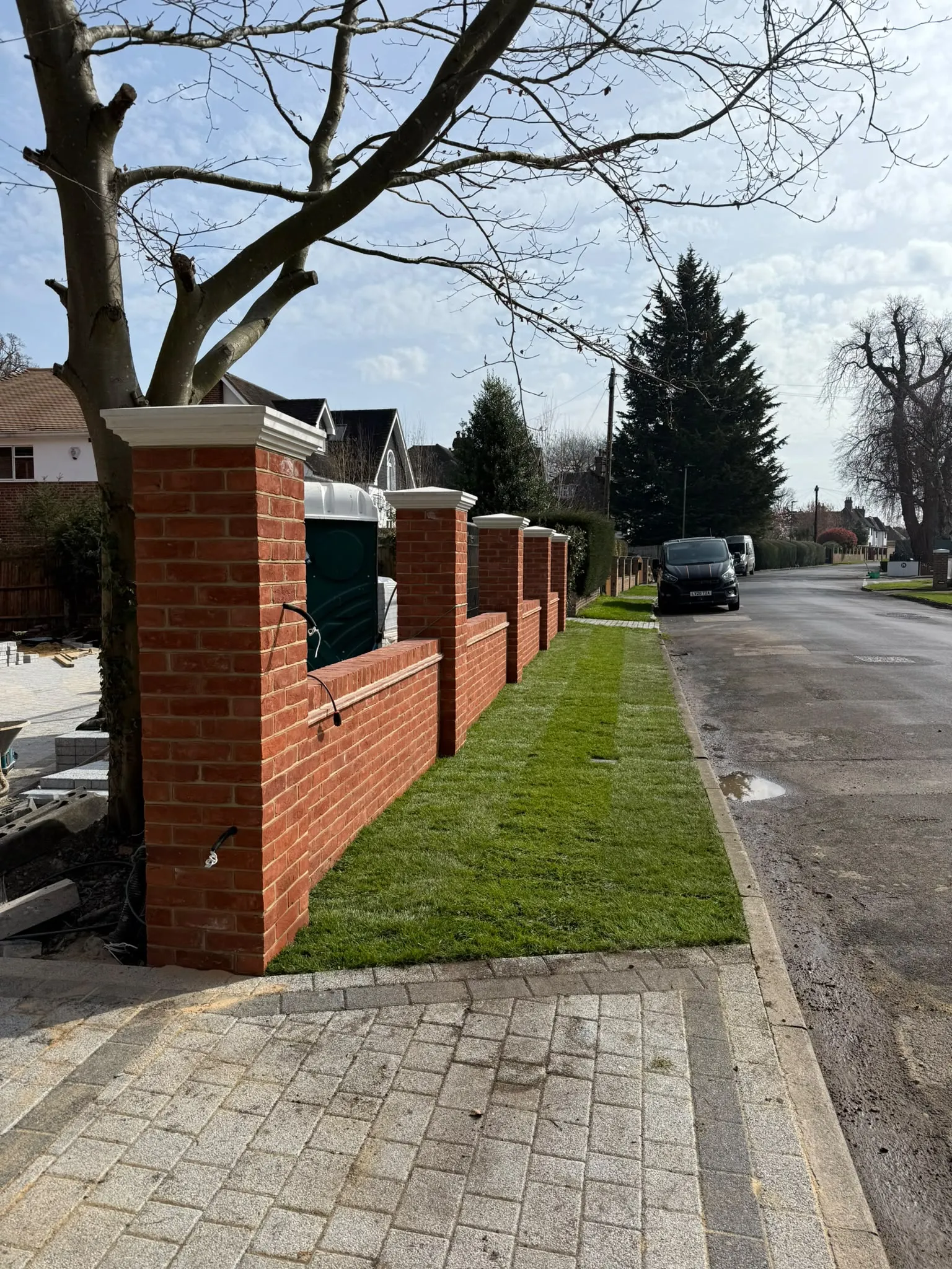 Red brick front boundary wall with piers and stone caps built by Prestige Landscapes