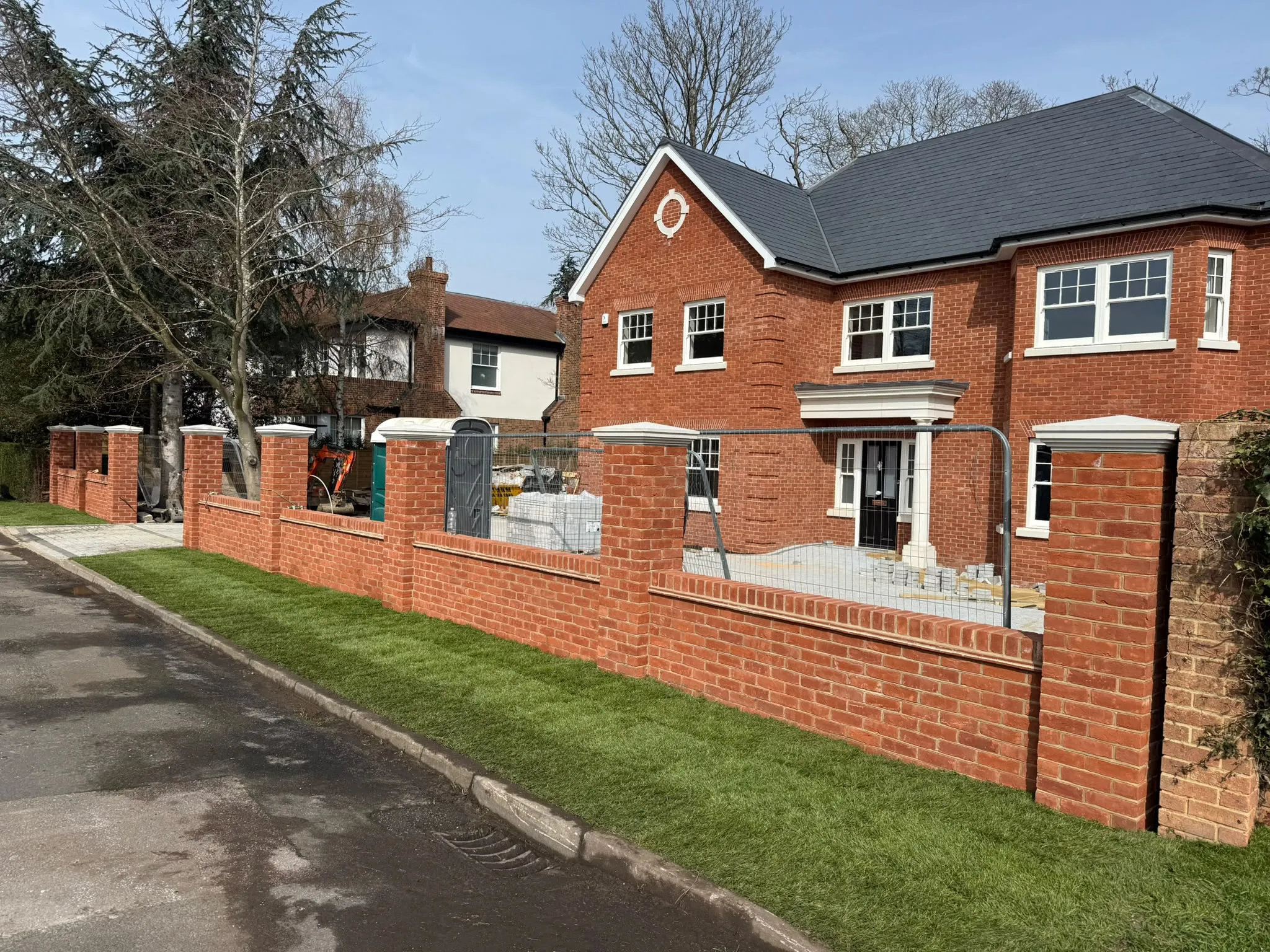 New red brick boundary wall and piers to a large home by Prestige Landscapes