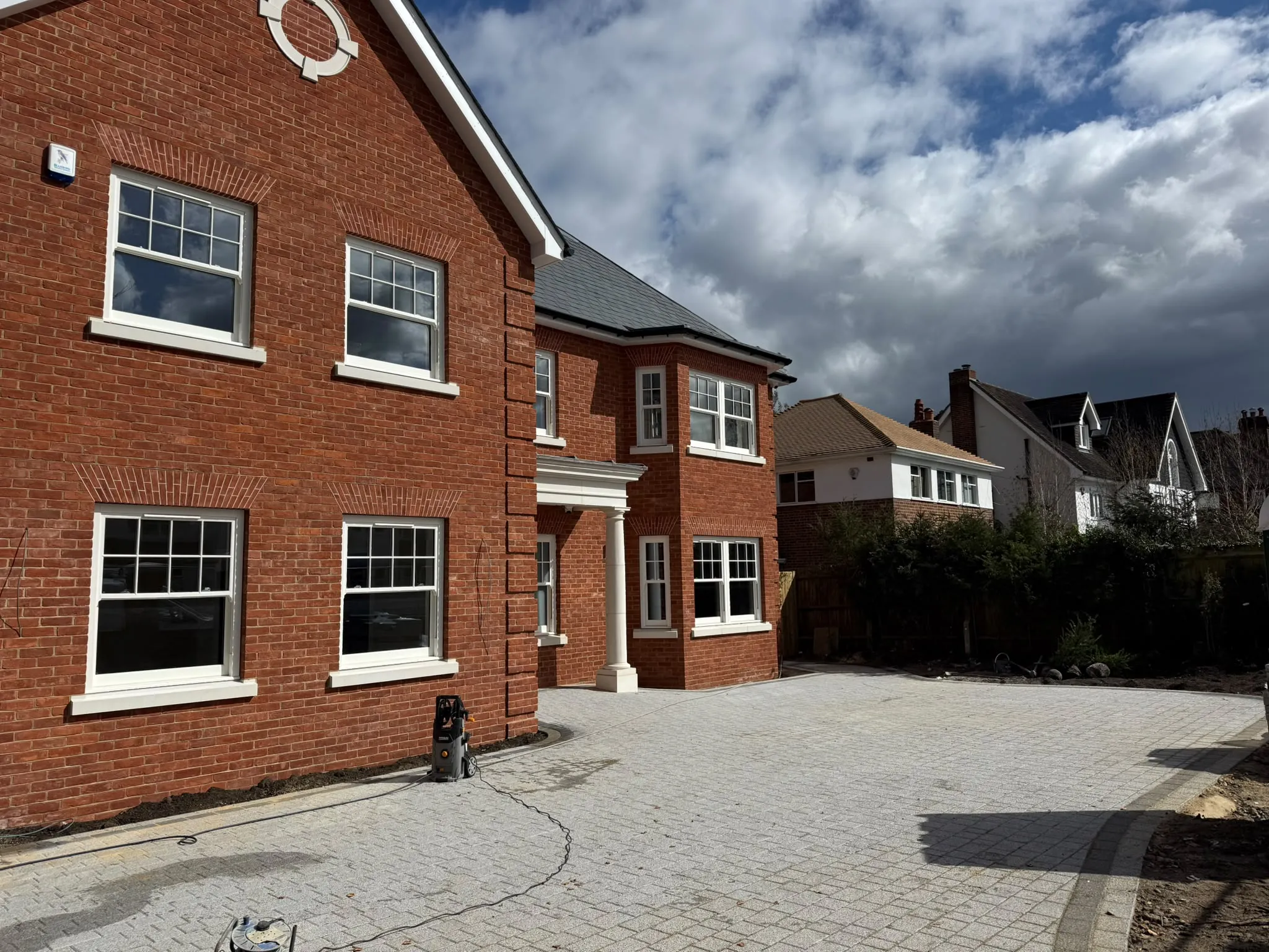 Block paving driveway to a large red brick home by Prestige Landscapes