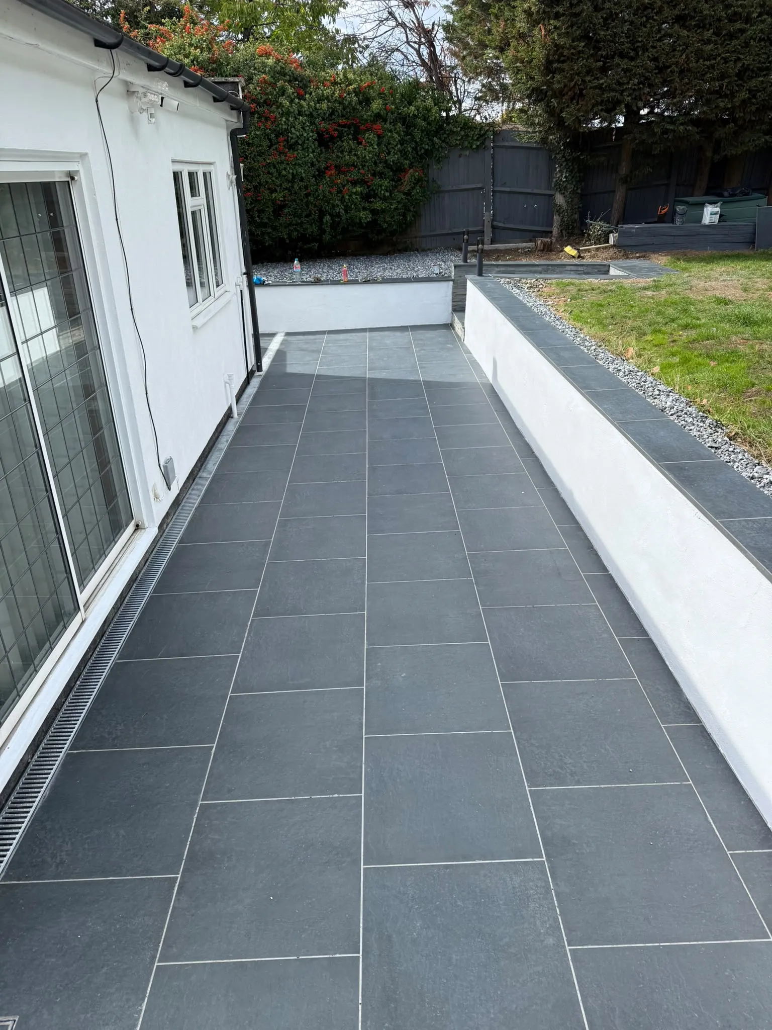 Charcoal porcelain side path with rendered raised bed by Prestige Landscapes