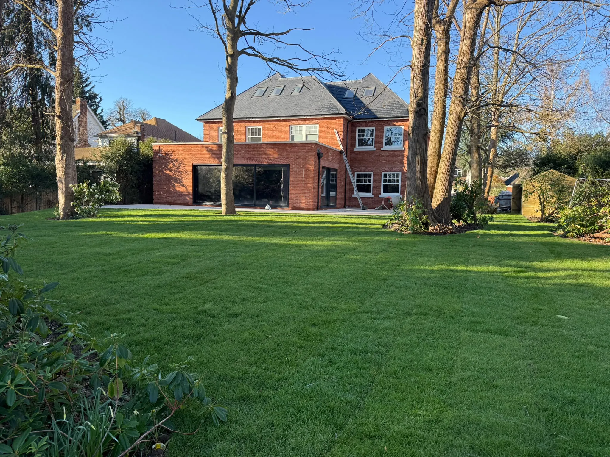 Large newly laid lawn behind a country home turfed by Prestige Landscapes