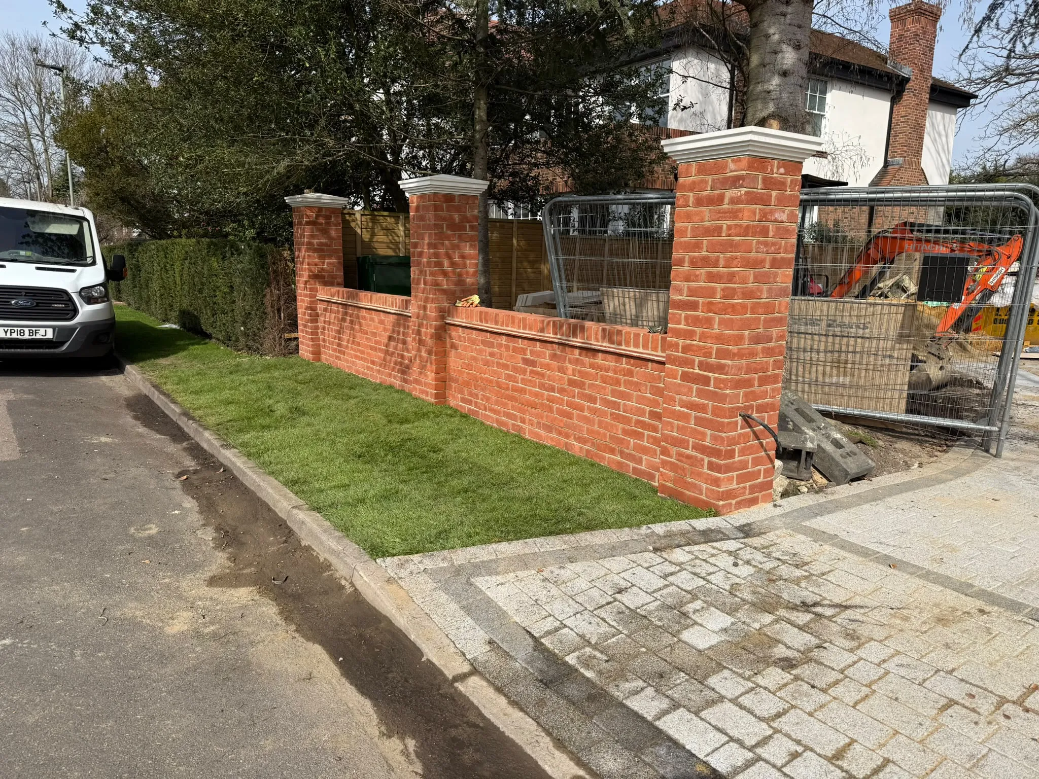 Red brick boundary wall with piers under construction by Prestige Landscapes