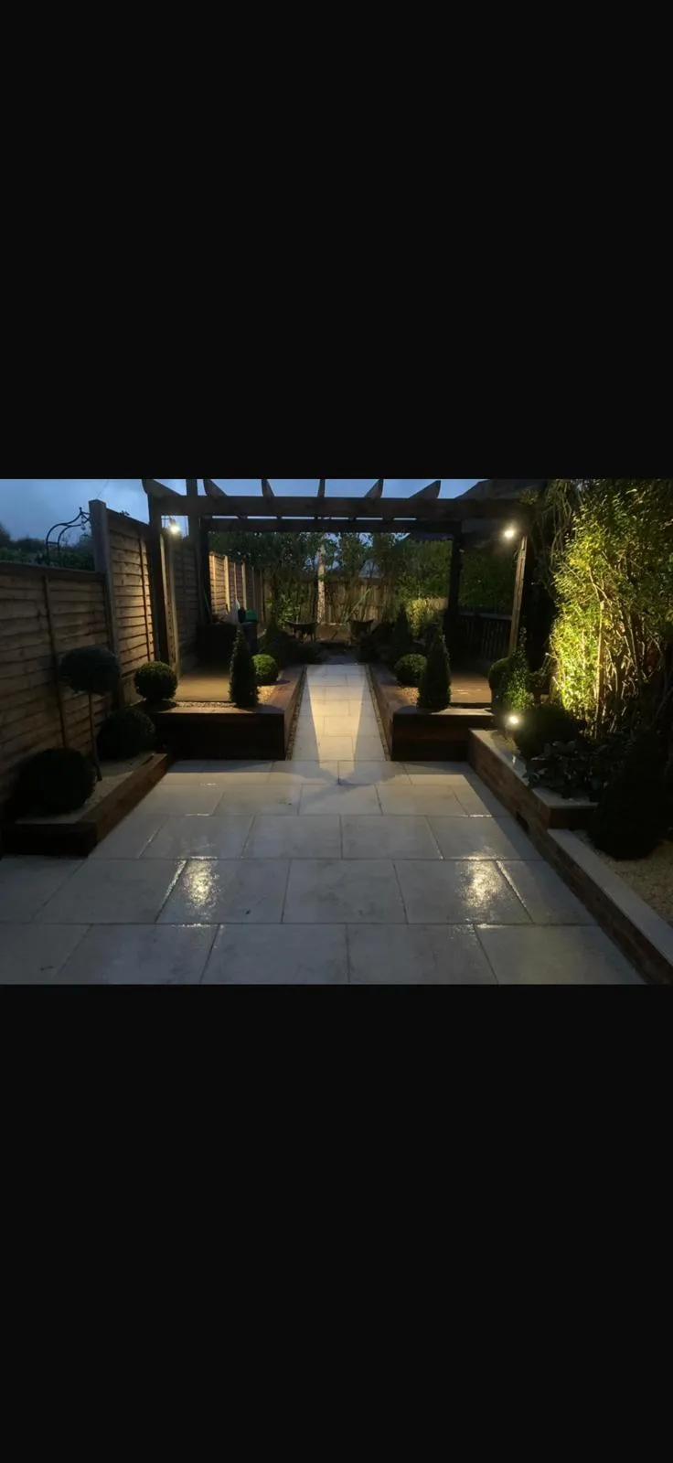 Evening garden lighting scheme with uplit pergola by Prestige Landscapes