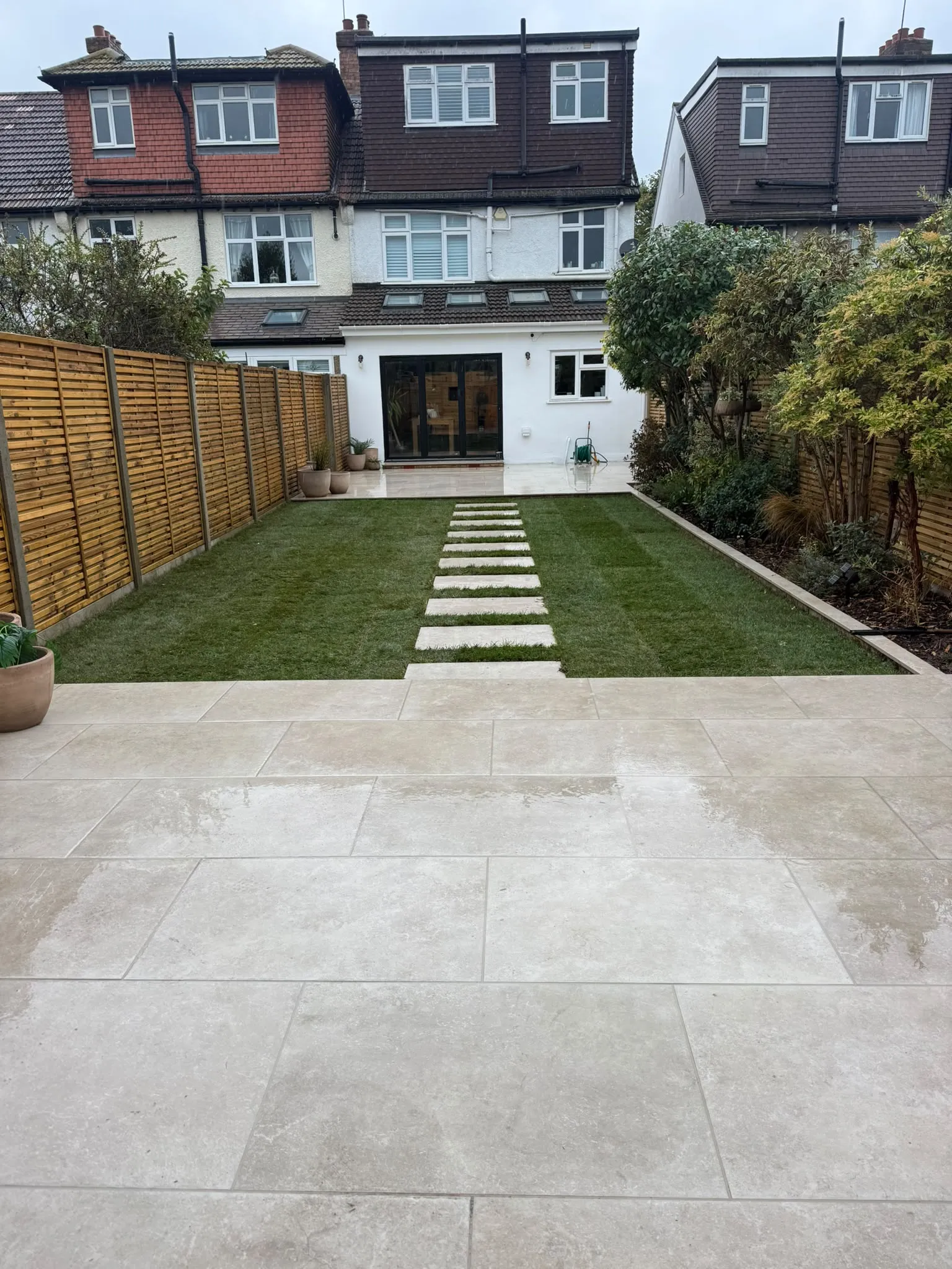 Finished Beckenham garden looking to the house with porcelain patio and artificial lawn