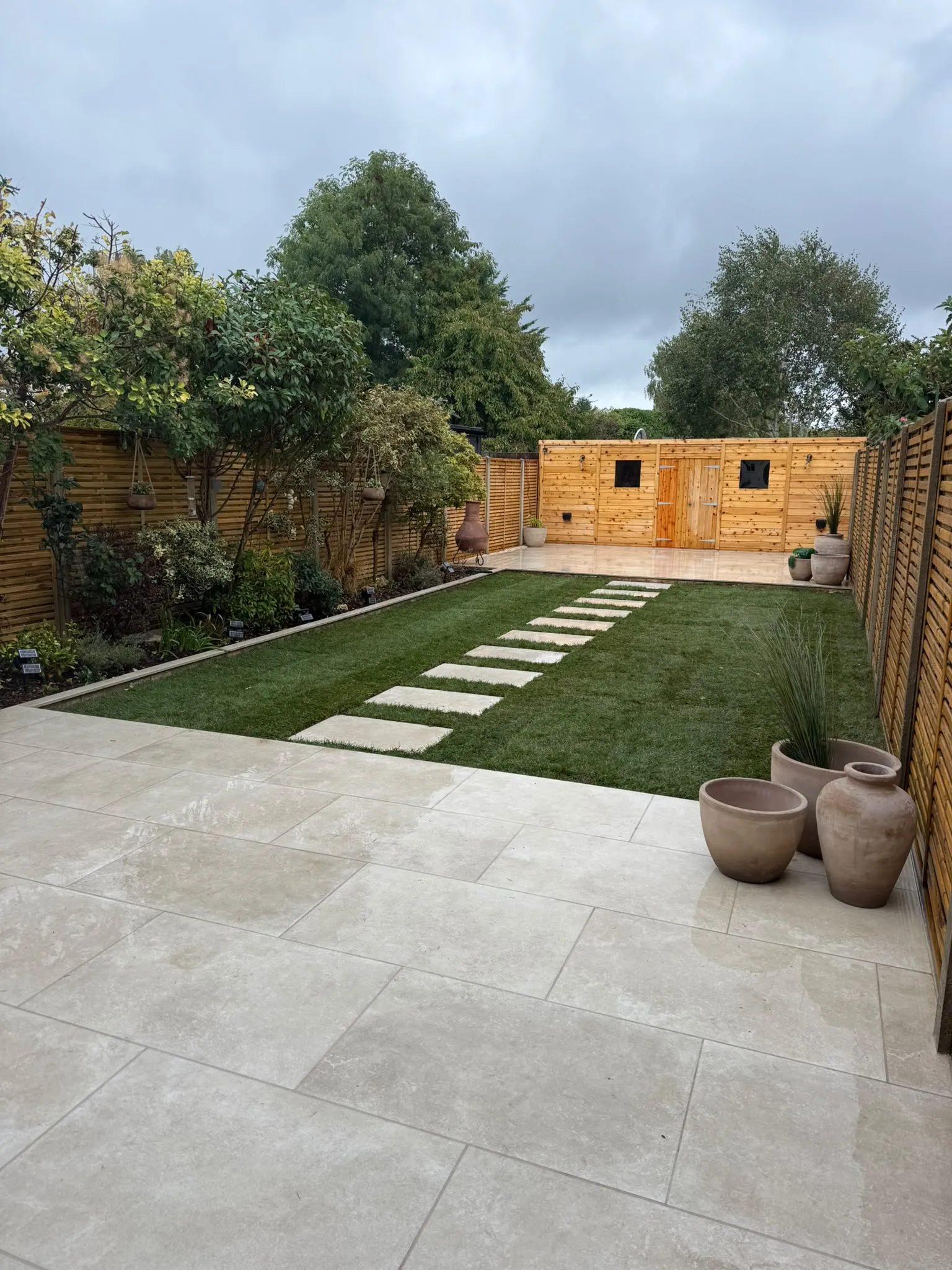 Finished porcelain patio and garden room with pots in a Beckenham garden by Prestige Landscapes