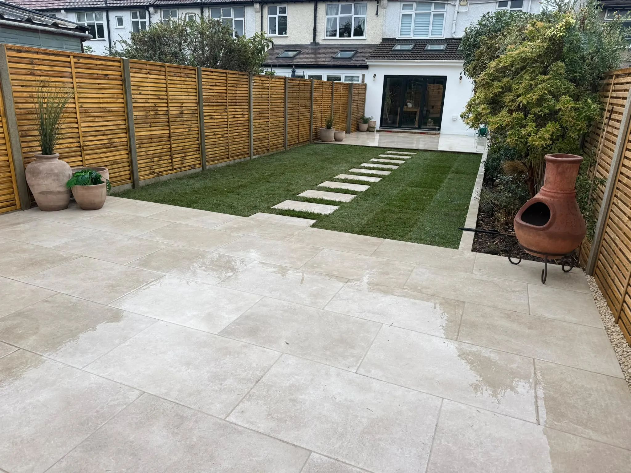 Finished porcelain patio and artificial lawn in a Beckenham garden by Prestige Landscapes